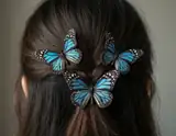 Three blue monarch butterflies with black veins rest delicately in dark brown hair tied in a low bun.