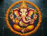 A colorful Ganesha design surrounded by orange marigolds on dark stone tiles