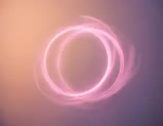 Soft glowing pink rings floating against a peach and lavender gradient background